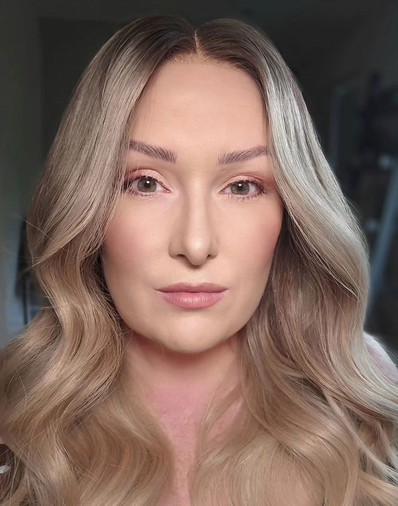Customer wearing a long ash blonde wavy wig