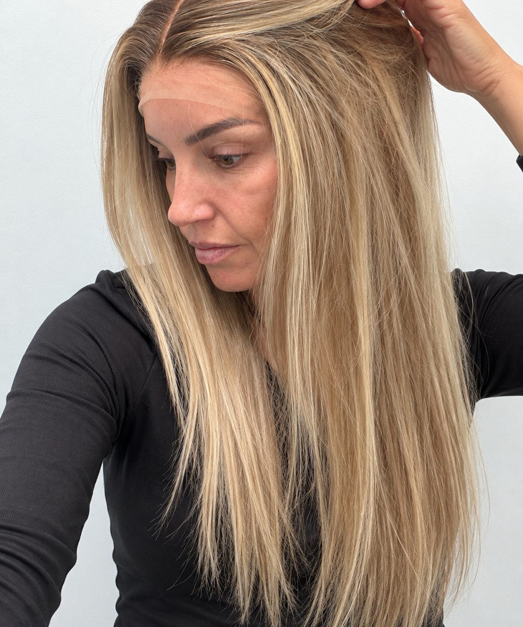 Champagne Melt 24-inch straight wig in rooted champagne blonde balayage, side view showing the hairline