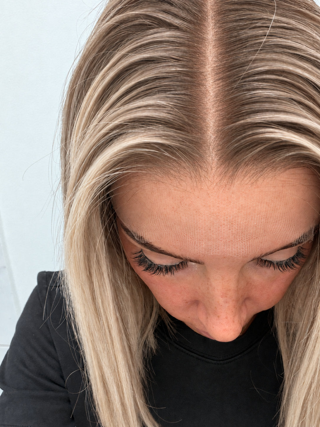 Close-up of the natural lace hairline and parting on a Champagne Melt human hair wig in rooted champagne blonde balayage