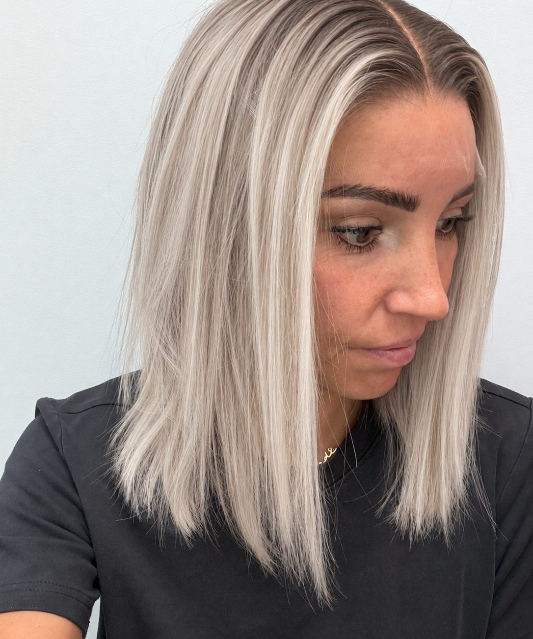 Nordic Pearl 14-inch blunt bob wig in rooted platinum blonde, side view showing the hairline