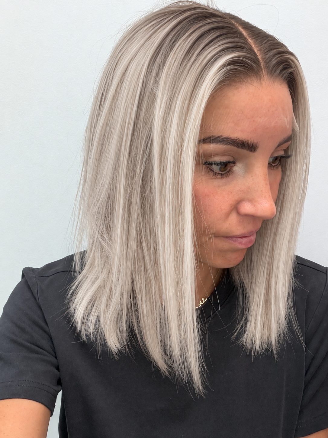 Nordic Pearl 14-inch blunt bob wig in rooted platinum blonde, side view showing the hairline