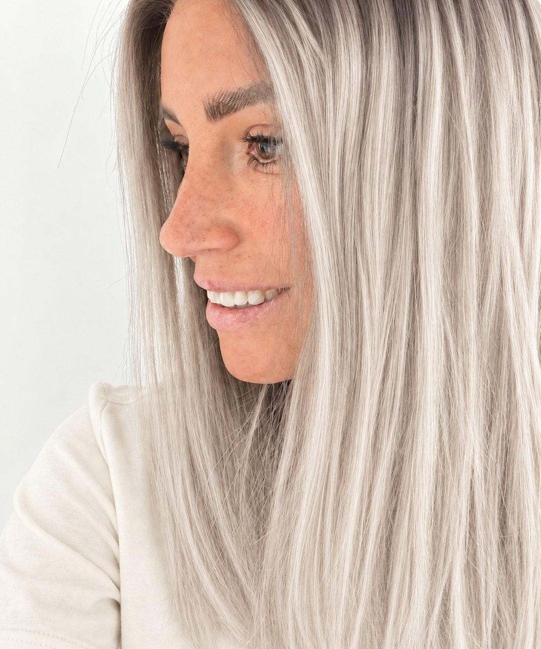 Nordic Pearl 16-inch layered straight wig in rooted platinum blonde, side view showing the hairline