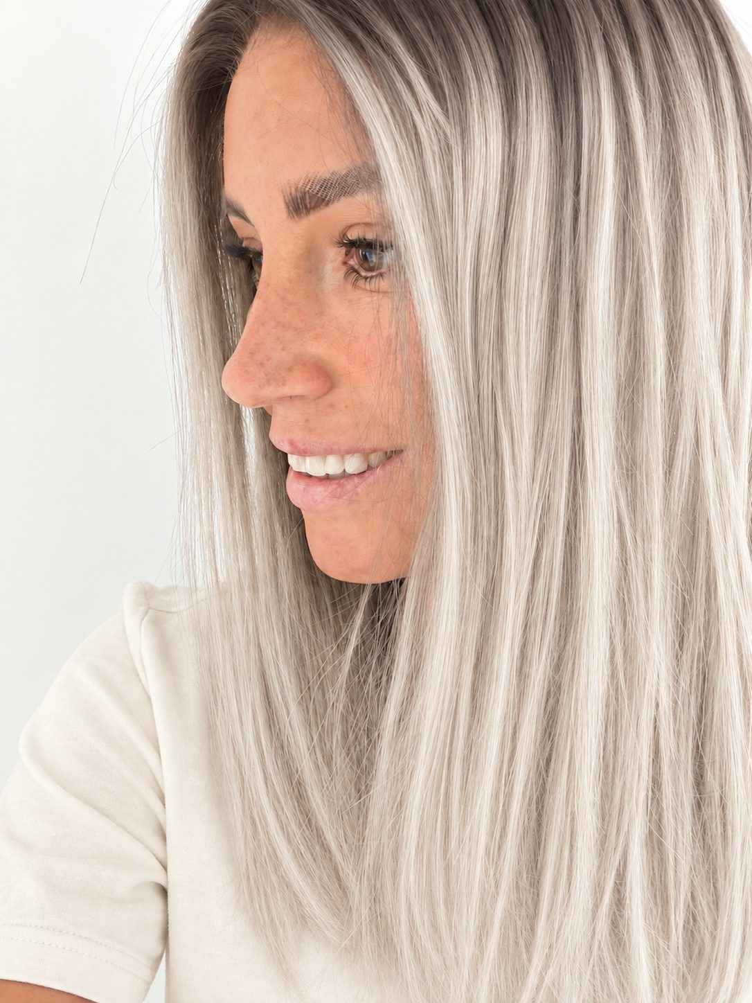 Nordic Pearl 16-inch layered straight wig in rooted platinum blonde, side view showing the hairline
