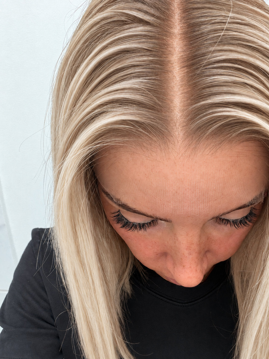 Close-up of the natural lace hairline and parting on a Vanilla Sand human hair wig in rooted beige vanilla blonde